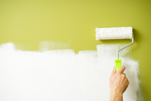 a paint roller against a green wall