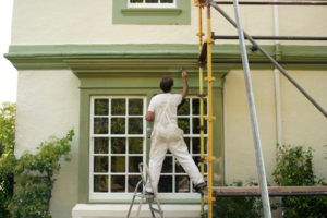 a painter painting the outside of a house 