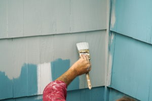 a homeowner painting the outside of their house